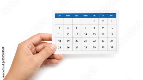 Hand holding a small monthly calendar card with numbered days and a blue weekday header on a clean white background