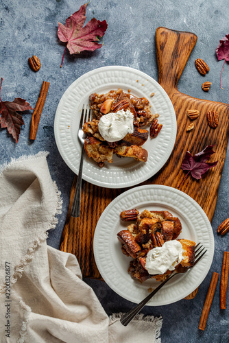 Two brown sugar butter pecan French toast servings topped with whipped cream.