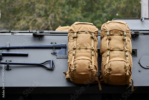 two combat backpacks attached to an armored vehicle