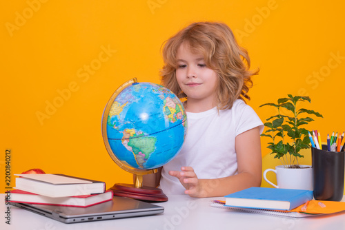Nerd pupil boy from elementary school with book isolated on yellow studio background. Smart genius intelligence kid ready to learn. Back to school.