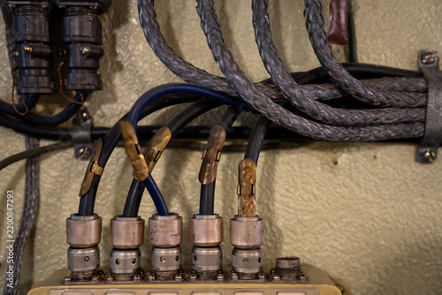 Obraz na plátně Braided electrical cables and wires connected with heavy duty metal connectors and terminals to industrial switchboard panel indoors