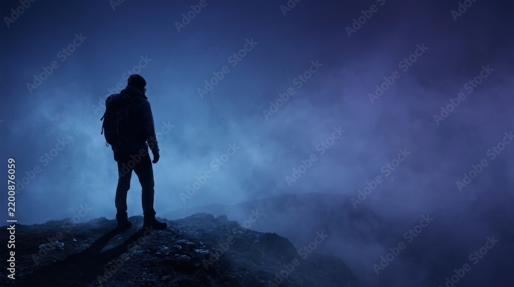 Fototapeta premium Minimalist Hiker Silhouette on Cobalt Blue Misty Mountain for Horror Advertising