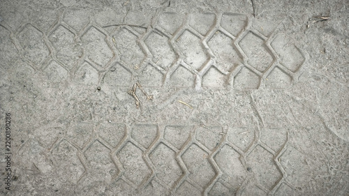 High-angle close-up of tire tread tracks imprinted on dry dusty soil