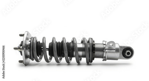 Metallic car suspension strut featuring a polished silver coil spring designed for high performance racing vehicles on white background isolated