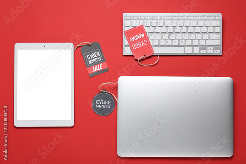 Gadgets and tags with text CYBER MONDAY on red background