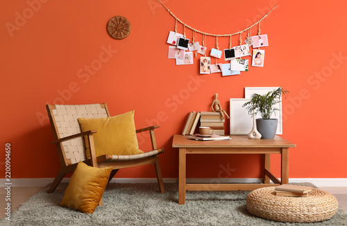 Interior of living room with wooden armchair, coffee table and pictures