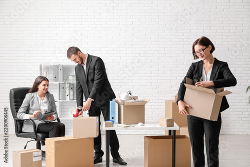 Business colleagues packing things in light office on moving day