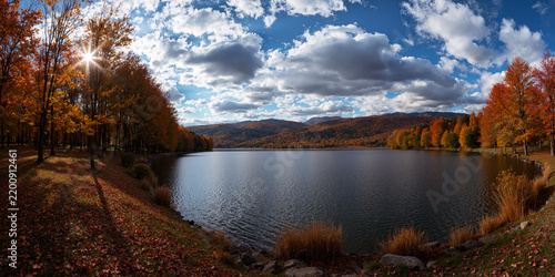 Sunburst Over a Mountain Lake Ringed by Autumn Forest
