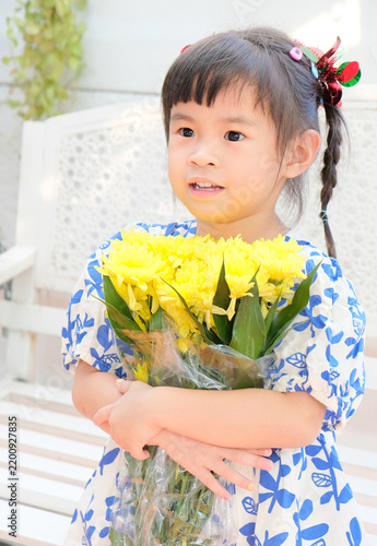 Young Asian Girl Holding Yellow Chrysanthemum Flowers Outdoors