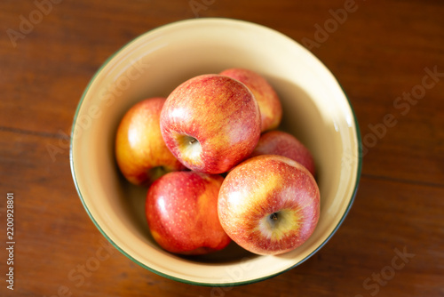 Close-up of red apples in a yellow bowl.