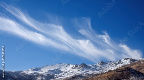 Serene Mountain Landscape Under Blue Sky with Wispy Clouds