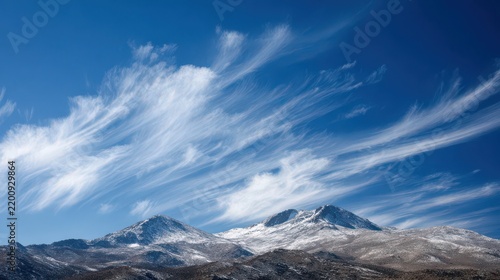 Majestic Mountain Peaks Under a Bright Blue Sky with Cloud Patterns