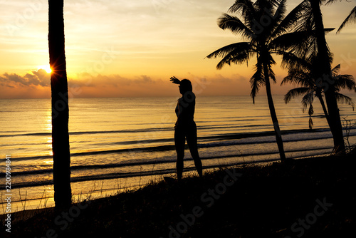 Sunrise with silhouette woman and coconut