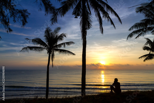 Sunrise with silhouette woman and coconut