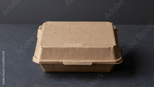 Simple brown cardboard shipping box on dark surface