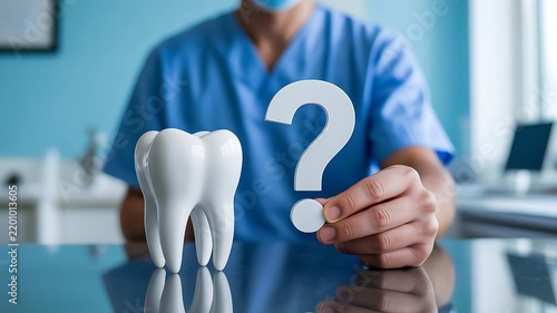 Dental care concept with dentist holding a tooth model and question mark
