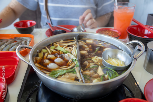 bubbling hot pot filled with a variety of ingredients, including vegetables, noodles, and meat.