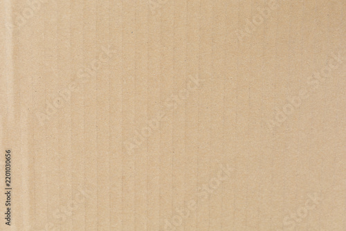 Close-up of textured beige corrugated cardboard surface, showcasing vertical ridges and subtle shading.