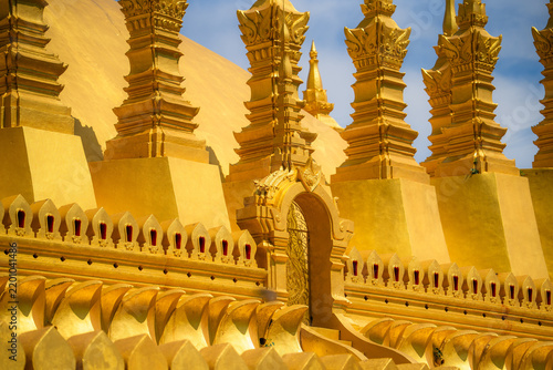 Golden buddhist temple architecture with ornate decorative details under blue sky