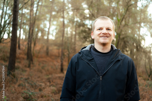 Smiling man enjoying nature in a forest park