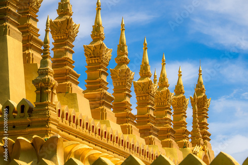 Golden buddhist temple architecture against blue sky – ornate lao-Style religious architecture
