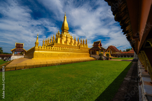 Golden pha that luang stupa and traditional buddhist temple in vientiane, laos under blue sky