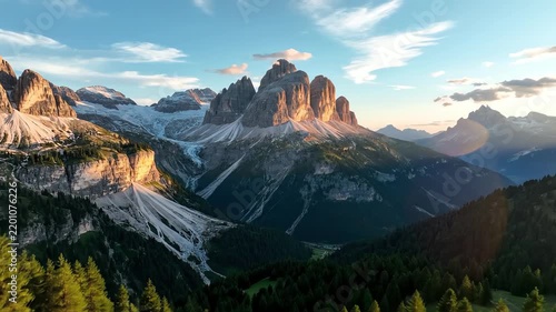 Majestic mountain peaks with glaciers and pine forest at sunset