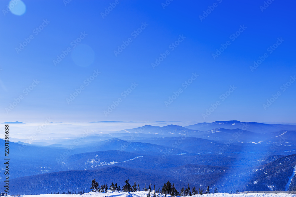 Obraz premium Aerial view of mountain ridges in soft fog. Beautiful white blue Peaks fades into distance. Minimal Nature abstract landscape, natural gradient color, environment winter serenity, panoramic skyline.