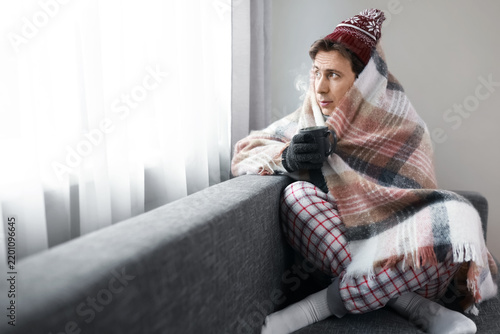 Quadro su tela Man freezing at home amidst central heating failure and energy crisis