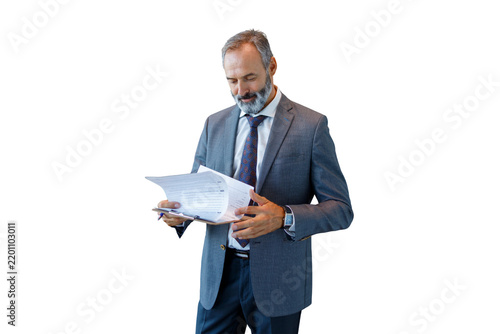Experienced businessman reviewing documents holding clipboard