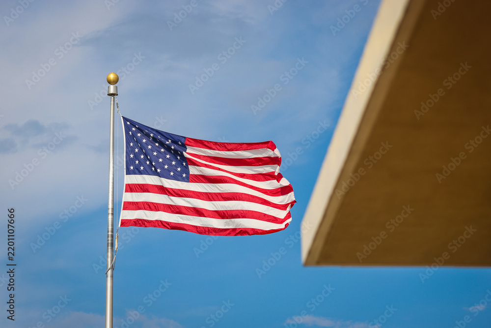Obraz premium The United States of America flag waving in the wind on a sunny day