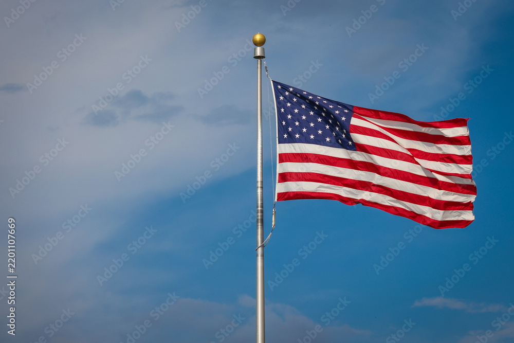Obraz premium The United States of America flag waving in the wind on a sunny day