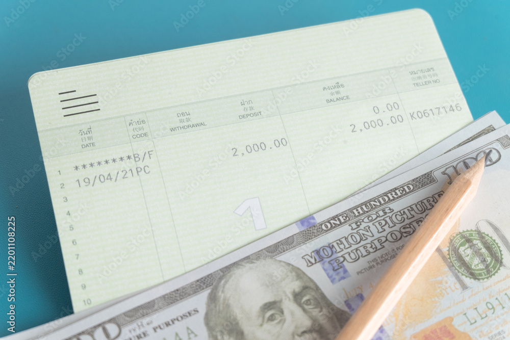 Obraz premium Close up of a bank savings passbook, US dollar bills and a wooden pencil on a blue background. Concept of personal finance, saving money, daily budgeting, wealth management and financial planning.