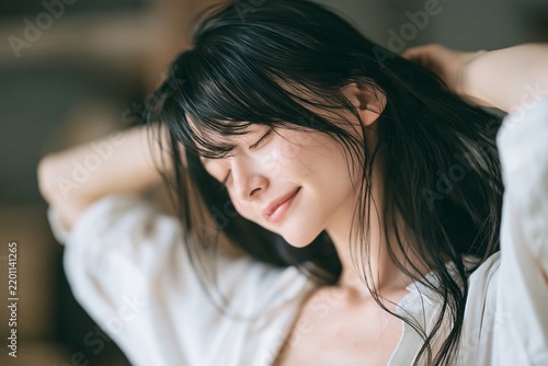 Tapety artystyczne 黒髪をかき上げ目を閉じる日本人女性の優しい笑顔リラックスする美しい時間