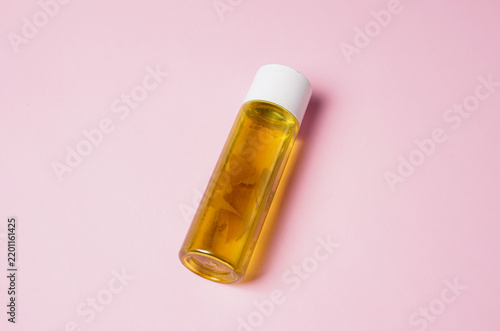 Skincare Serum Bottle With Amber Liquid on Pink Background