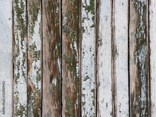 Weathered white and brown wooden planks with peeling paint and natural aged texture