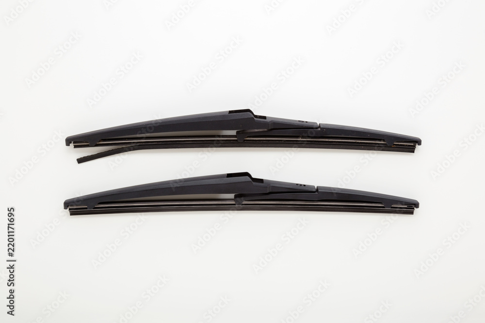 Obraz premium New and old car rear windshield wiper blades isolated on light gray table background. Closeup. Compare two objects. Car spare parts. Flat lay. Top down view.