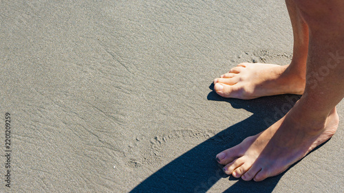 Female legs on sand beach