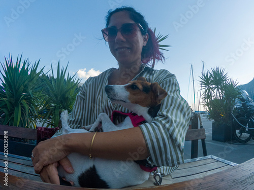 Canvas Print A beautiful dark-haired woman holds her white, brown, and black-furred Jack Russ