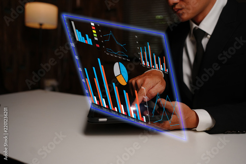 Businessman Analyzing Financial Data with Futuristic Virtual Screen and Graphics
