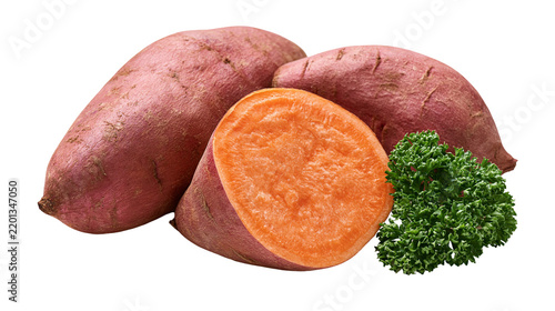 Whole and sliced raw sweet potatoes with fresh green parsley garnish