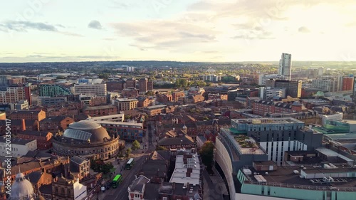 Ambient drone exploration of Leeds, West Yorkshire, England, United Kingdom. Aerial POV of Central City infrastructure, skyscrapers, old town buildings, river and transport in sunset, golden hour.