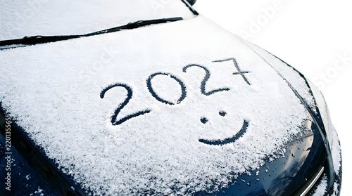 Car hood covered in snow with 2027 written and smiley face