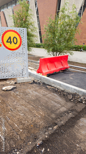Картината върху платно Urban road construction area with temporary speed limit sign and red safety barr