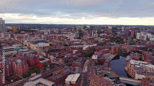 Ambient drone exploration of Leeds, West Yorkshire, England, United Kingdom. Aerial POV of Central City infrastructure, skyscrapers, old town buildings, river and transport in sunset, golden hour.