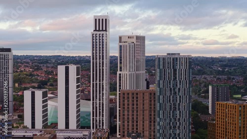 Ambient drone exploration of Leeds, West Yorkshire, England, United Kingdom. Aerial POV of Central City infrastructure, skyscrapers, old town buildings, river and transport in sunset, golden hour.