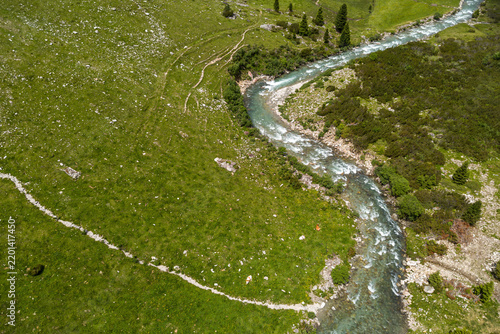 Wilderness and nature conservation, aerial view of a mountain stream in the Kitzbühel Alps in Tyrol Austria with pristine alpine landscape and green meadows
