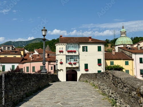 Scenic view of historic Pontremoli in Lunigiana, Tuscany, Italy, photographed from a stone bridge with traditional colorful buildings, green shutters.
