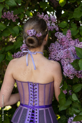 Feminine outdoor portrait with fragrant lilac blossoms and natural beauty
