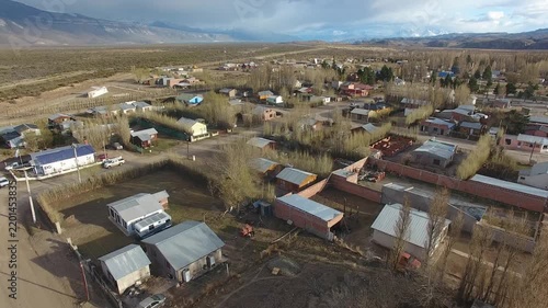 4K drone aerial view over Lago Posadas village in Santa Cruz, Argentina, revealing homes surrounded by rugged Patagonian landscapes, arid terrain and remote wilderness scenery.